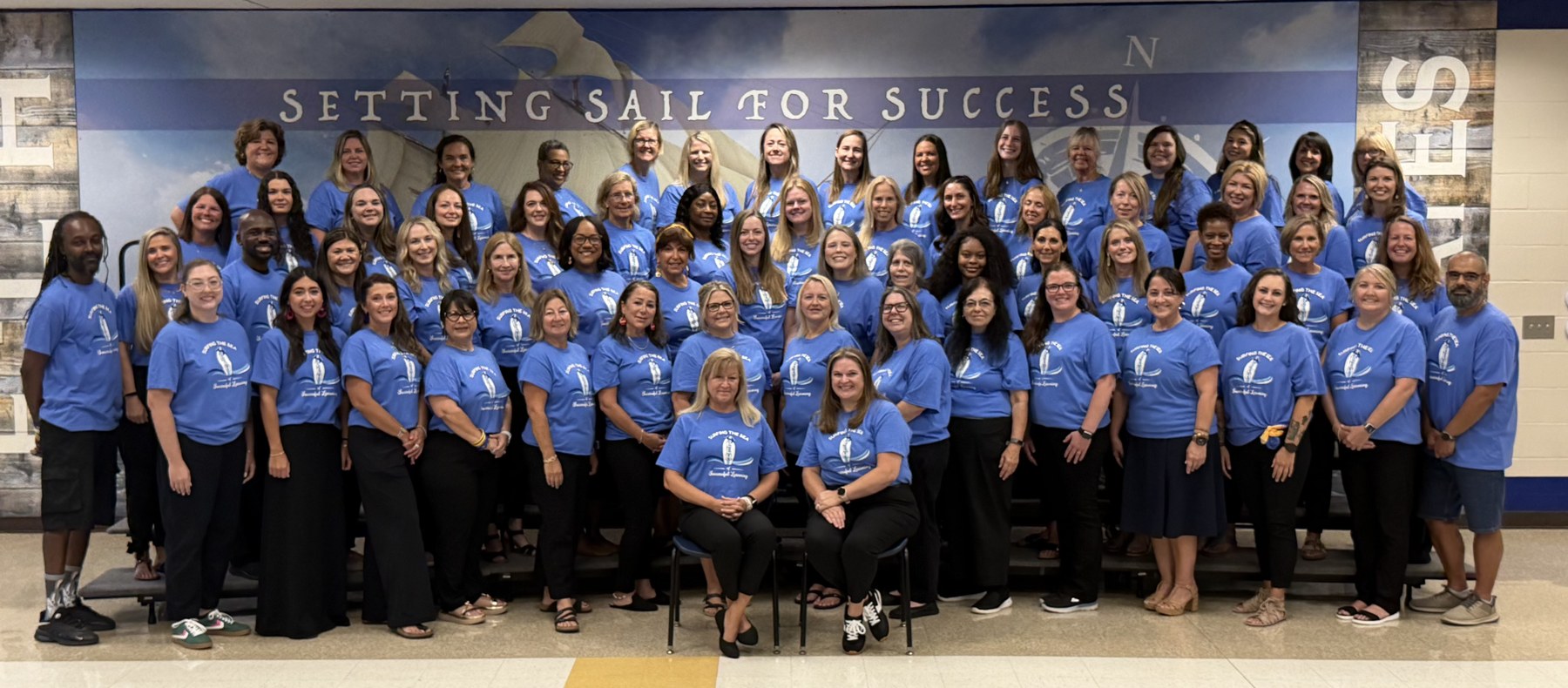 Emma Love Hardee Elementary school staff posing together in blue school shirts