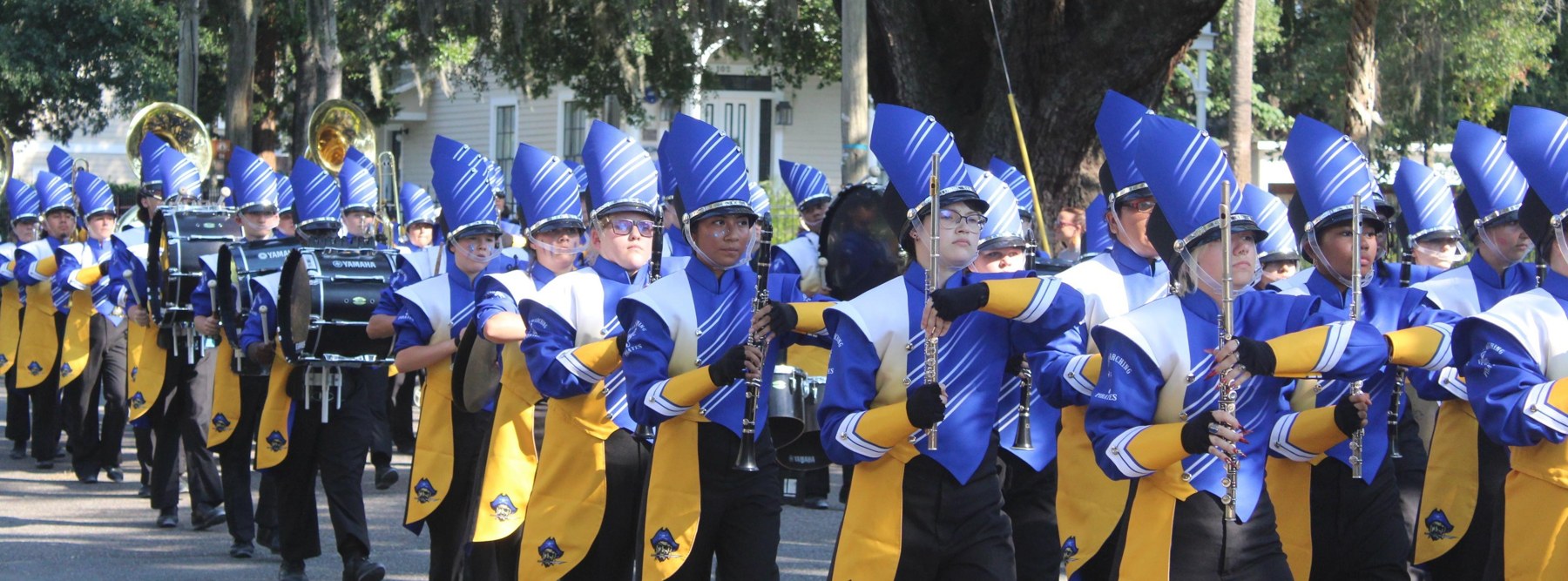 Fernandina Beach High School marching band performing outdoors in blue and gold uniforms